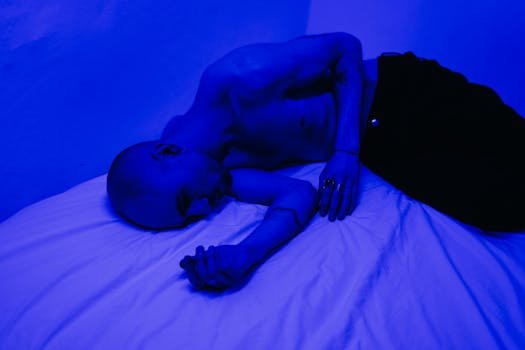 Man in a blue-lit room, expressing solitude and introspection.